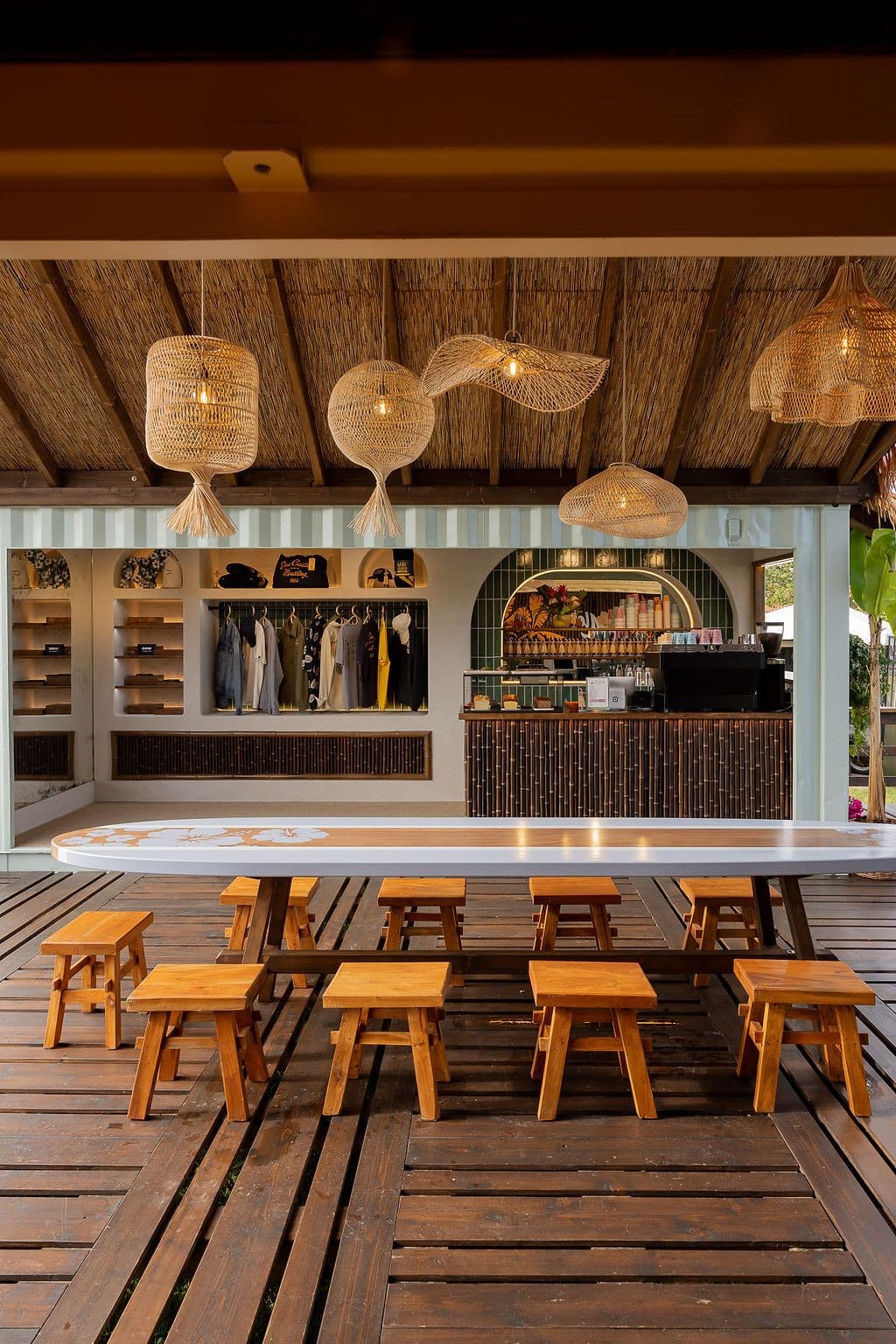 Intérieur du pavillon Breitling : comptoir, corner boutique et tabourets en bois sous des suspensions en osier
