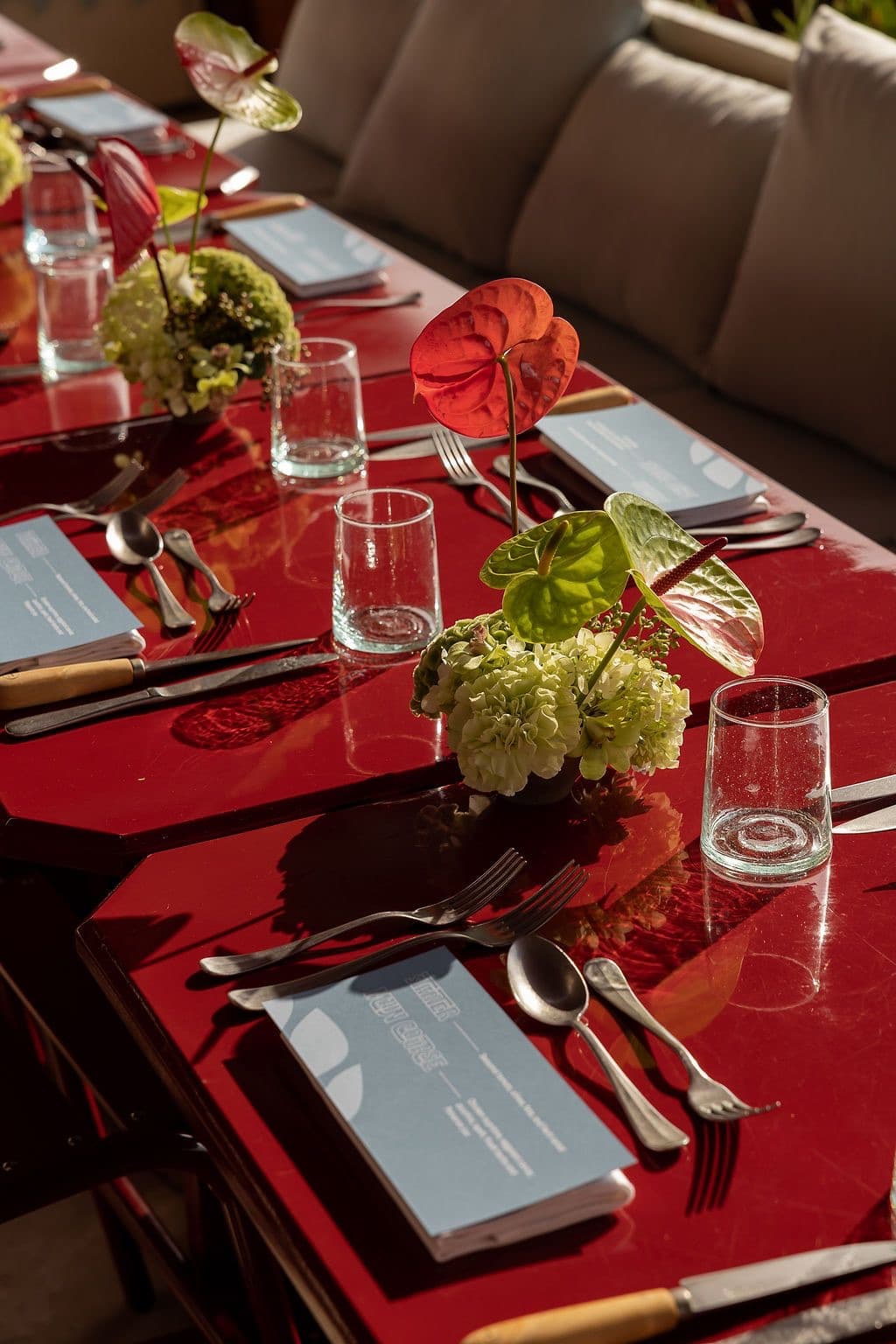 Table laid with red linen for a Breitling dinner, menus set at each place