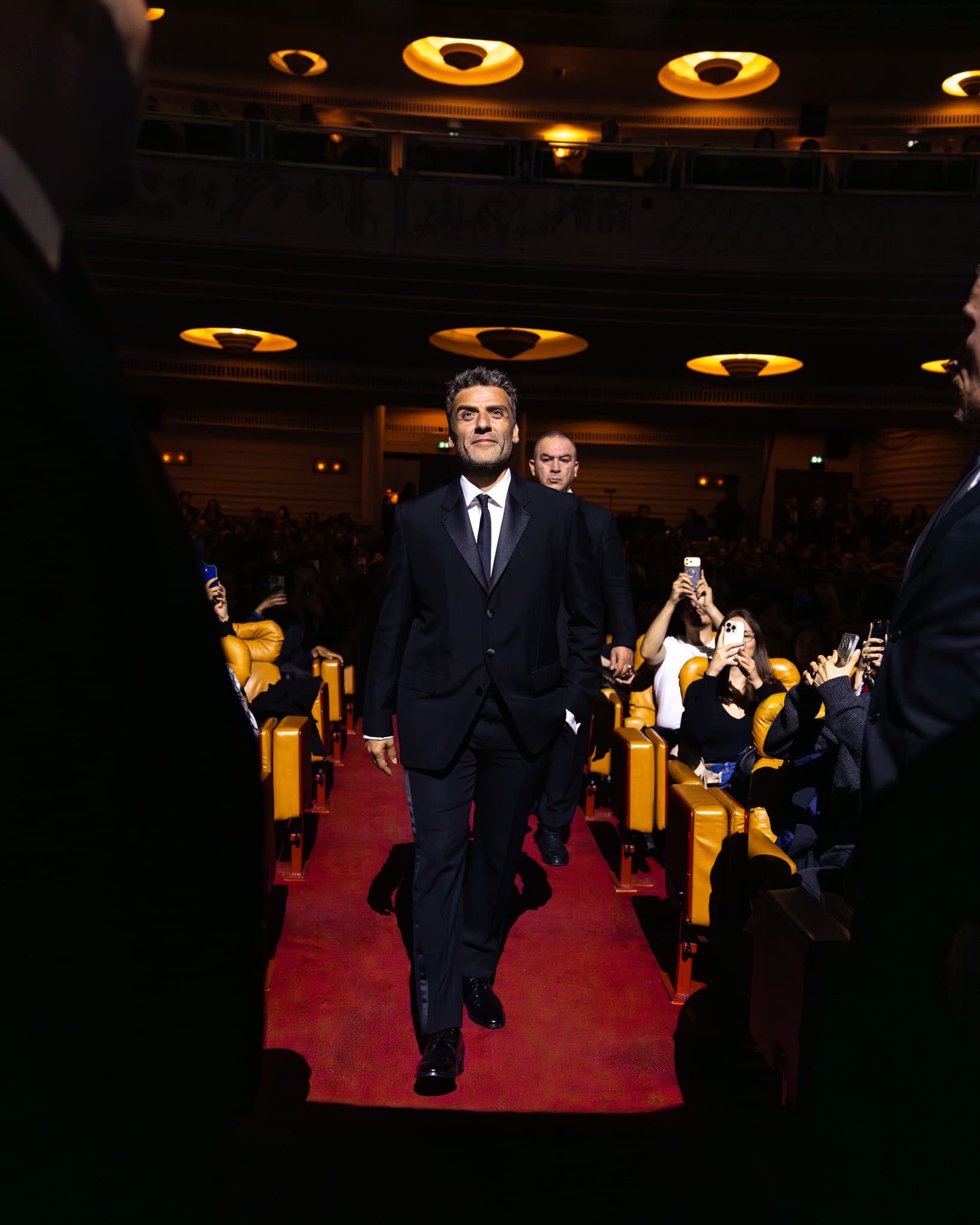 Arrivée d'un invité dans la salle du Grand Rex, allée centrale dégagée par la régie