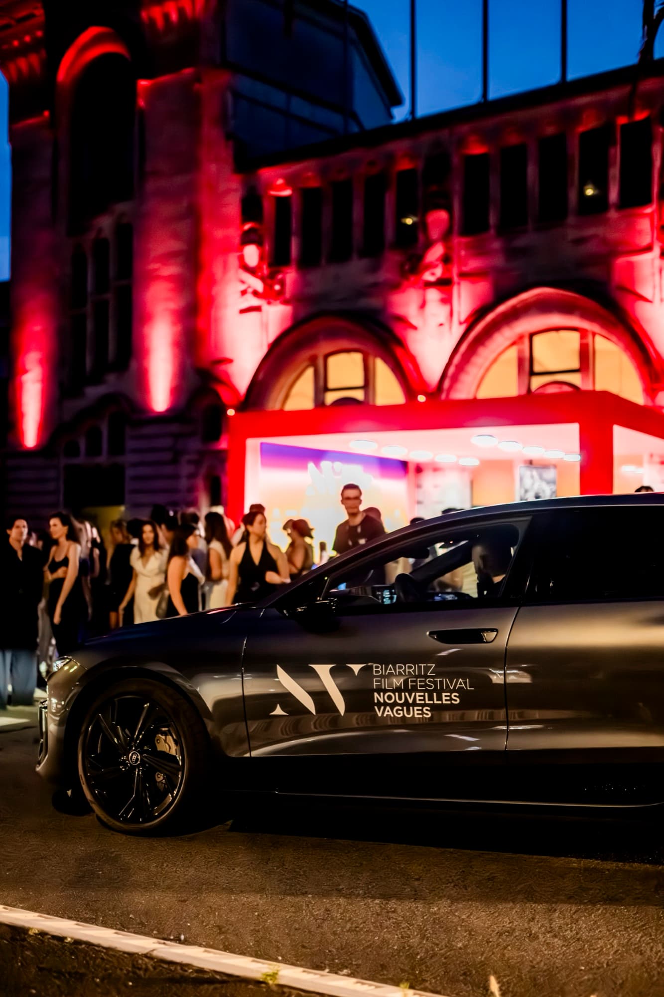 Guests dropped off by a Nouvelles Vagues festival car after dark