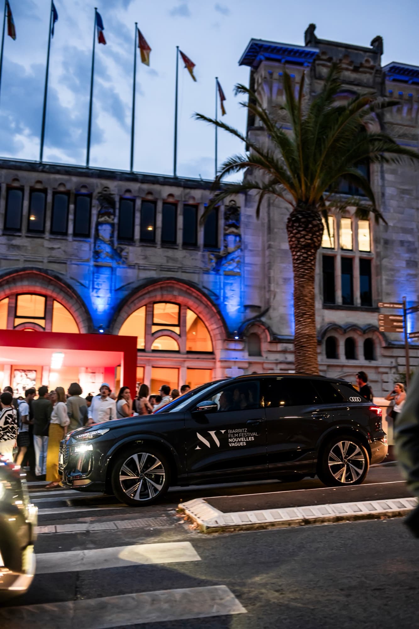 Navette du festival Nouvelles Vagues stationnée devant le Casino de Biarritz éclairé en bleu