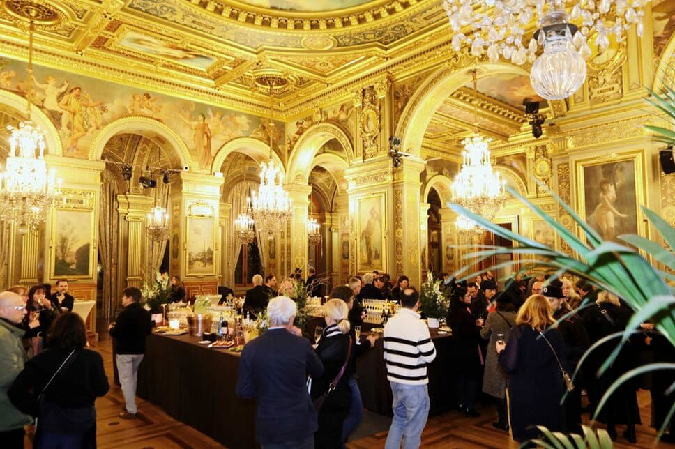 Réception Unifrance dans un salon doré, invités autour des buffets