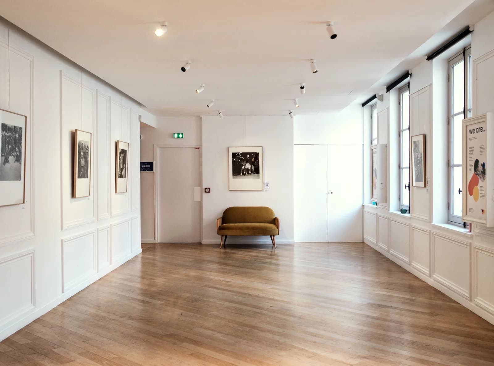 Galerie blanche de we are_ accrochée pour une exposition photo